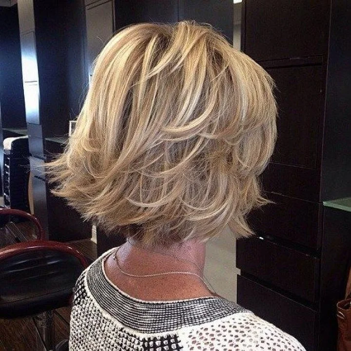 flattering summer haircuts for women over 50 2026 Layered Blonde Bob With Flicked Summer Ends