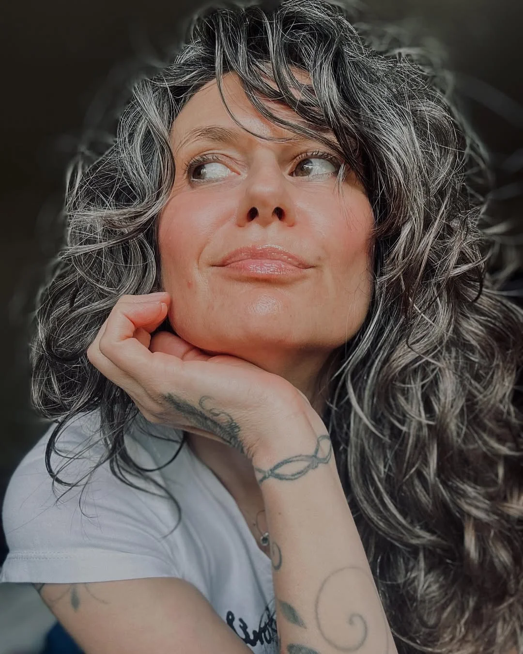 flattering summer haircuts for women over 60 2026 Voluminous Salt-and-Pepper Curls With Soft Fringe