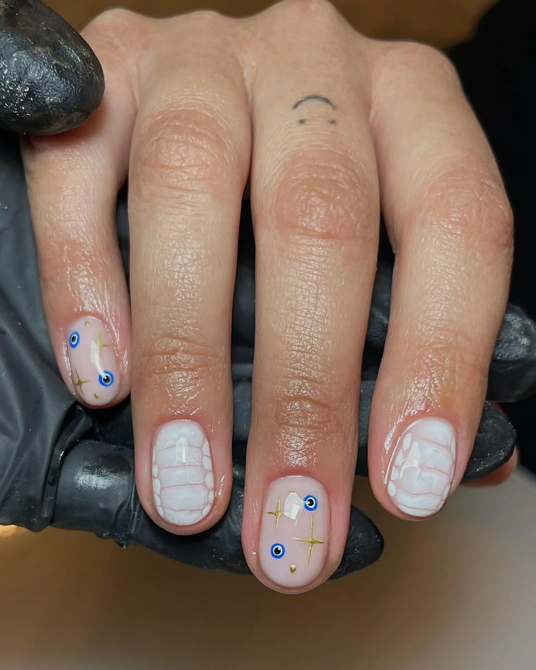 short gel nails summer 2026 Minimal White Gel Nails With Evil Eye And Gold Star Details