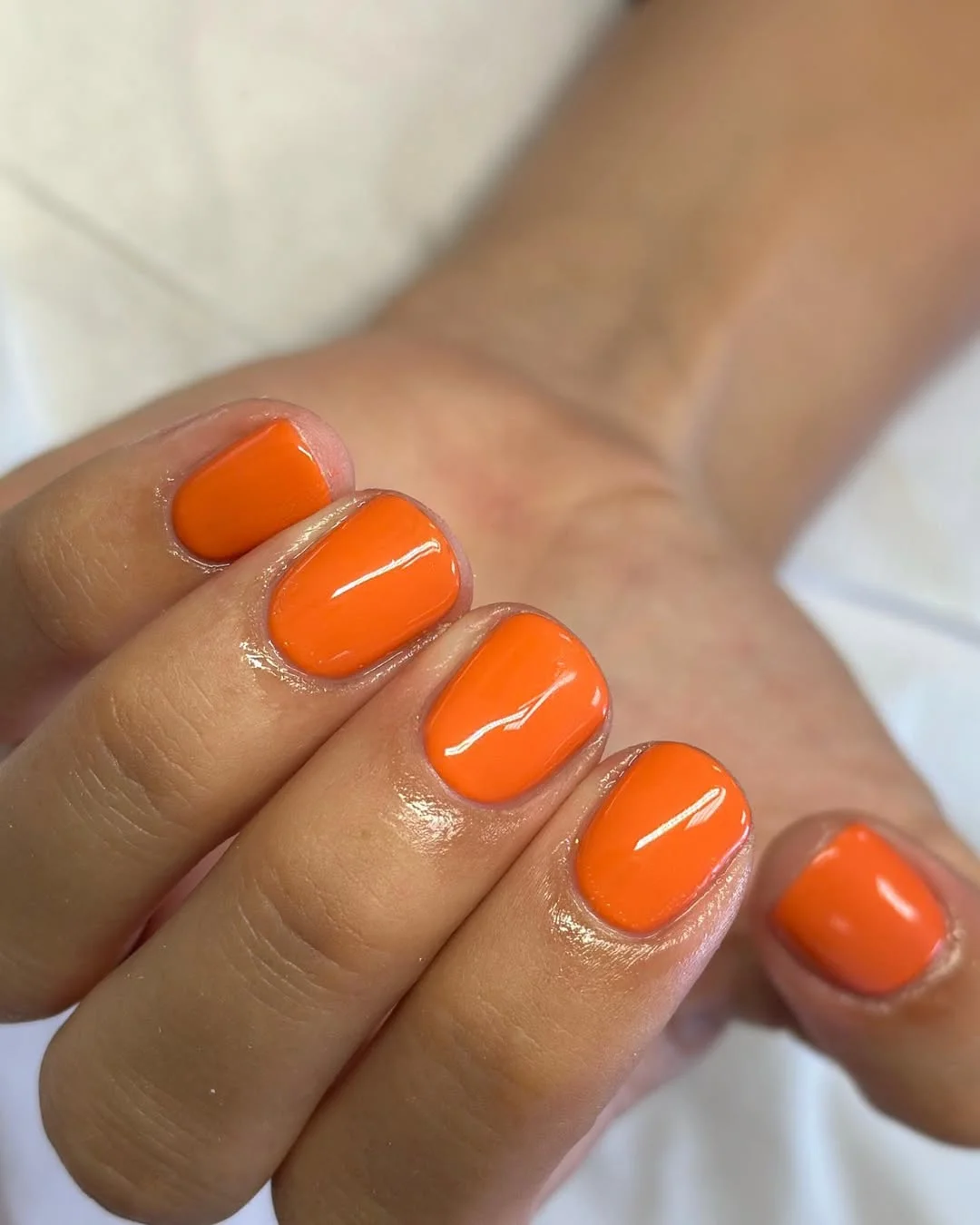 short squoval nails design 2026 Glossy Orange Short Squoval Nails for Hot Summer Days