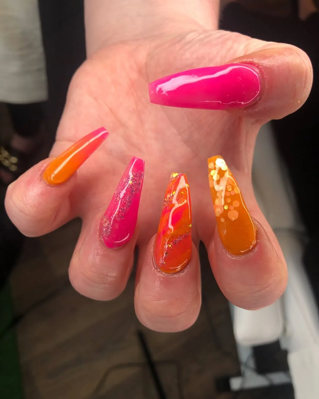 summer acrylic nails 2026 Pink and Orange Stiletto Nails With Sunset Glitter