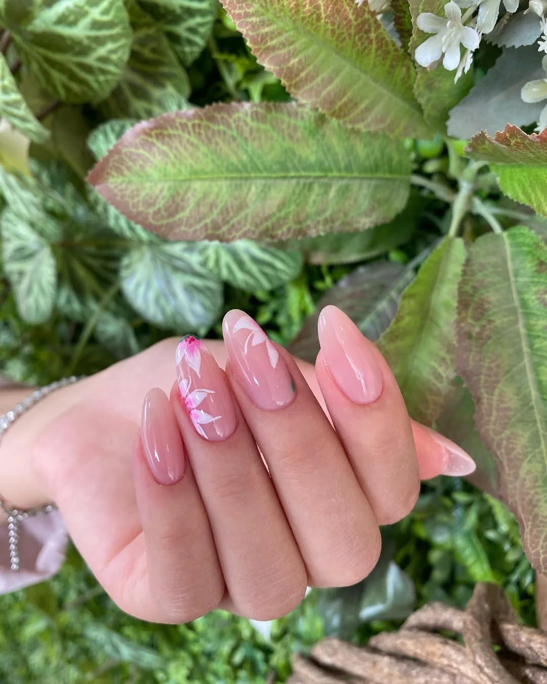 summer nail colors 2026 Glossy Pink Almond Nails With A Floral Accent