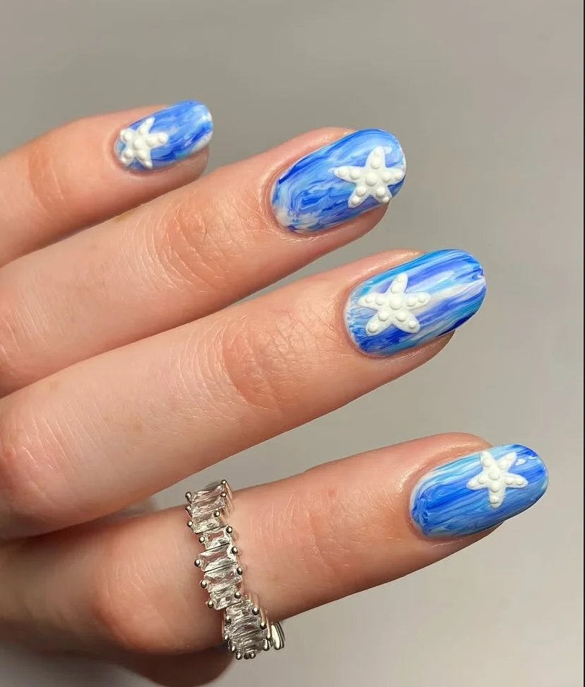 summer nail inspo 2026 Ocean Blue Marble Nails With White Starfish Accents