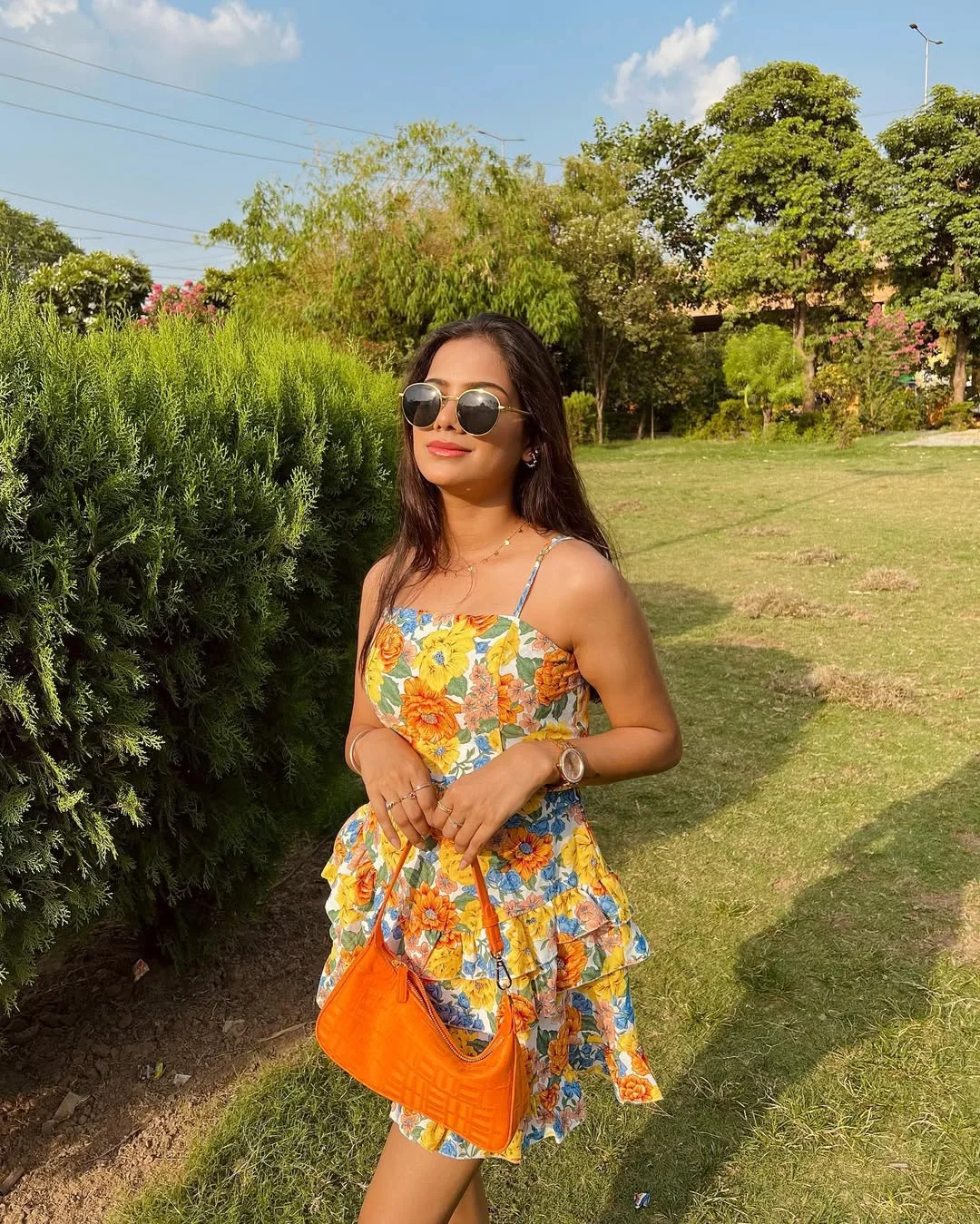 25 summer vacation resort outfits 2026 Garden Floral Mini Dress With A Bright Orange Bag