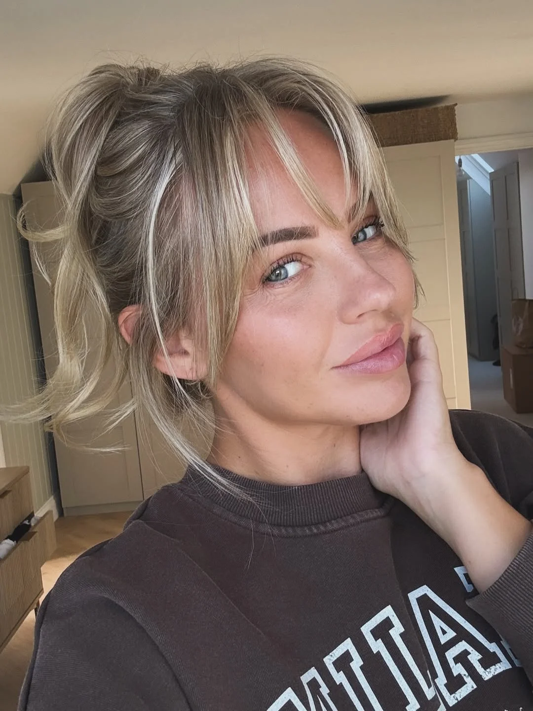 youthful summer haircuts for women over 40 2026 Soft Blonde Fringe With an Easy Summer Ponytail