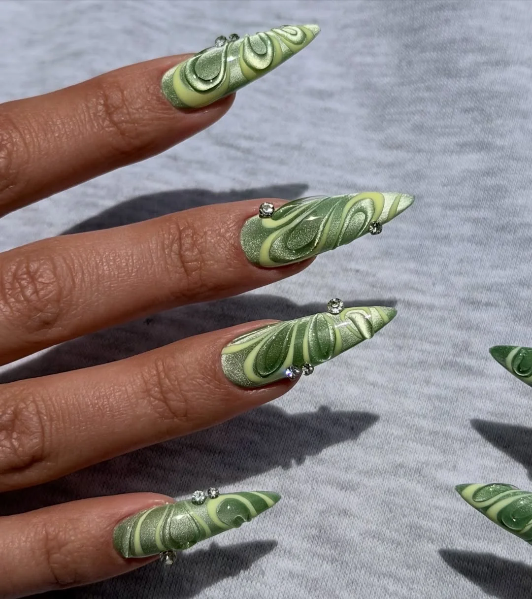 july nail colours ideas 2026 Celery Chrome Stiletto Nails With Sculpted 3D Swirls