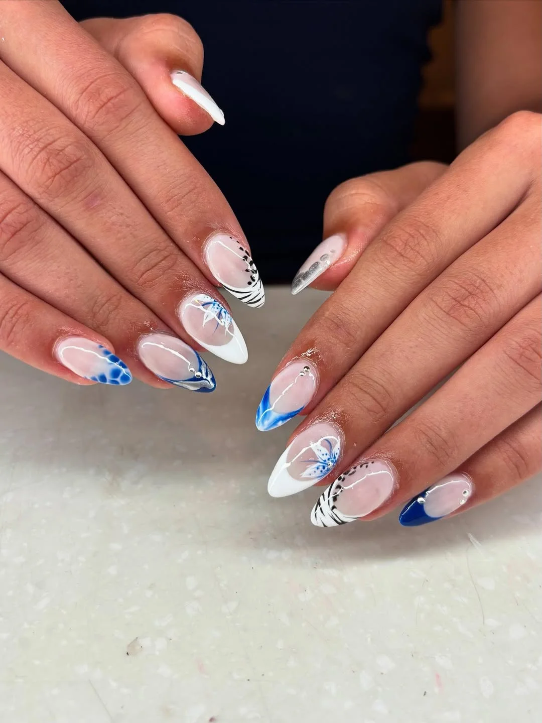july nails design ideas 2026 Blue And White French Tips With Graphic Floral Lines