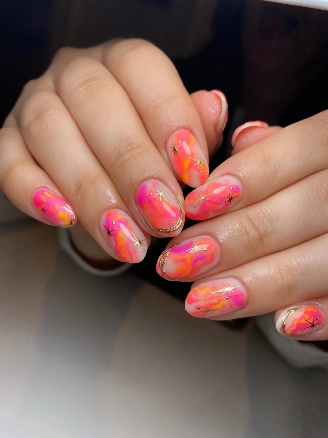 july nails design ideas 2026 Hot Pink And Orange Aura Nails With Gold Starbursts