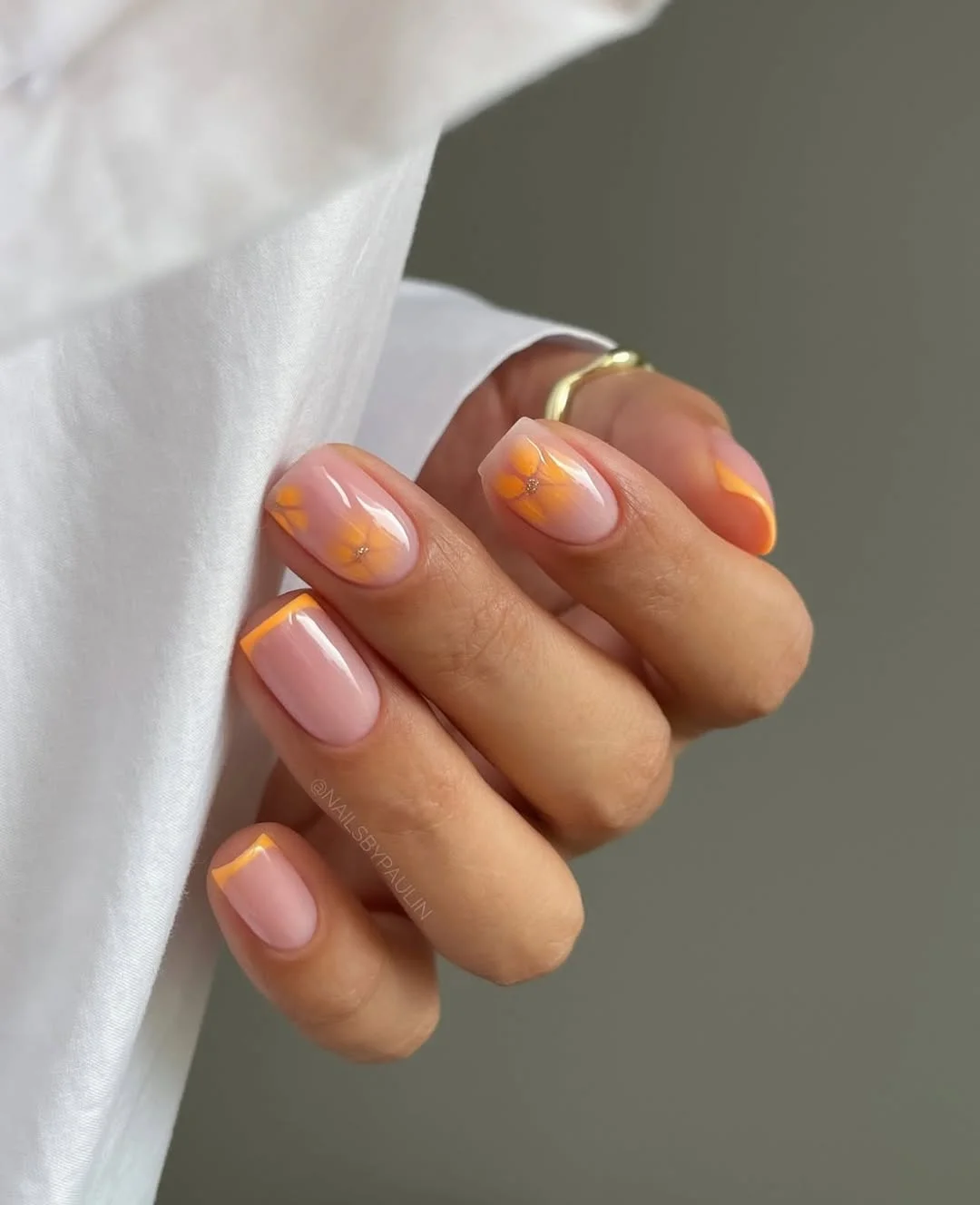 june manicure ideas 2026 Soft Pink Nails With Orange French Tips and Tiny Flowers
