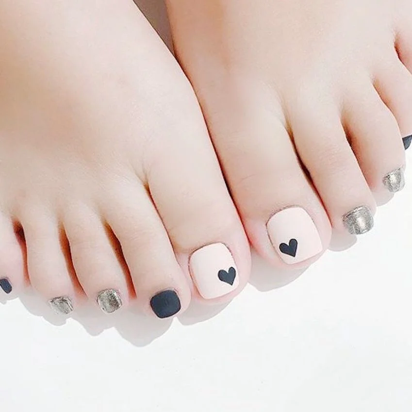 summer pedicure nail art 2026 Soft Nude Pedicure With Tiny Black Heart Accents